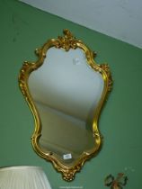 A contemporary shaped gilded framed Wall hanging Mirror, 34 3/4'' high x 19 1/2'' wide approx.