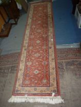 A bordered, patterned and fringed "Royal Keshan" wool Runner in terracotta, 111'' x 27''.