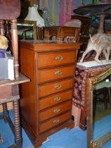 A contemporary Mahogany finished Tallboy with five Drawers plus a fall-front upper compartment for