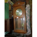 An Oak cased Wall Clock having a silvered face with Arabic numbers,