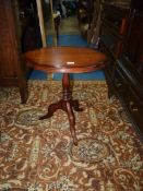 An oval Mahogany occasional Table standing on a turned pillar with three shaped feet,