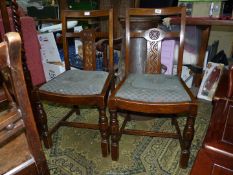 A pair of Oak framed side Chairs standing on turned front legs and having drop in seats.