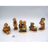 Five Hummel figures including boy with a bird, boy with umbrella and shopping bag,