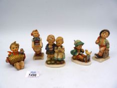 Five Hummel figures including boy with a bird, boy with umbrella and shopping bag,