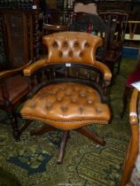 A brown hide upholstered buttoned detailed swivel and tilt Office Armchair,