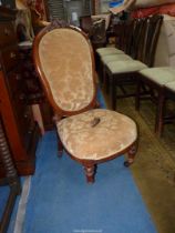 A circa 1900 Mahogany framed nursing chair standing on turned and fluted front legs and upholstered