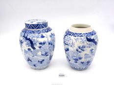 A pair of hand painted blue and white oriental ginger jars, one lid missing, 19cm tall.