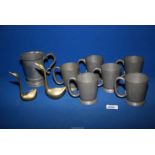 A quantity of pewter tankards and two brass swans.