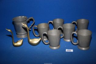 A quantity of pewter tankards and two brass swans.