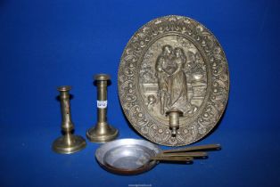 A set of three small copper and brass frying pans, two brass candlesticks,