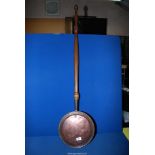 An antique copper warming pan.