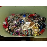 A large green case of costume jewellery including bead necklaces, bracelets, etc.