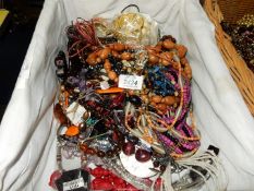 A wicker tray of costume jewellery incluidng bead necklaces, etc.