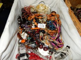 A wicker tray of costume jewellery incluidng bead necklaces, etc.