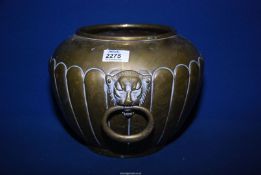 A brass bucket/jardiniere having lion head handles to either side.