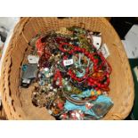 A large wicker basket of costume jewellery, bead necklaces, etc.