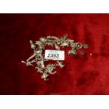 A sterling silver charm bracelet with a large quantity of charms, some marked sterling,