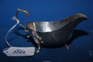 A silver sauce boat with scalloped edge rim standing on three hoof feet, London 1898, weight 118.