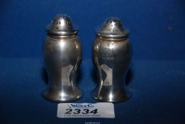 A pair of silver pepper pots, Birmingham 1919, makers mark rubbed, 36.51 grams total.