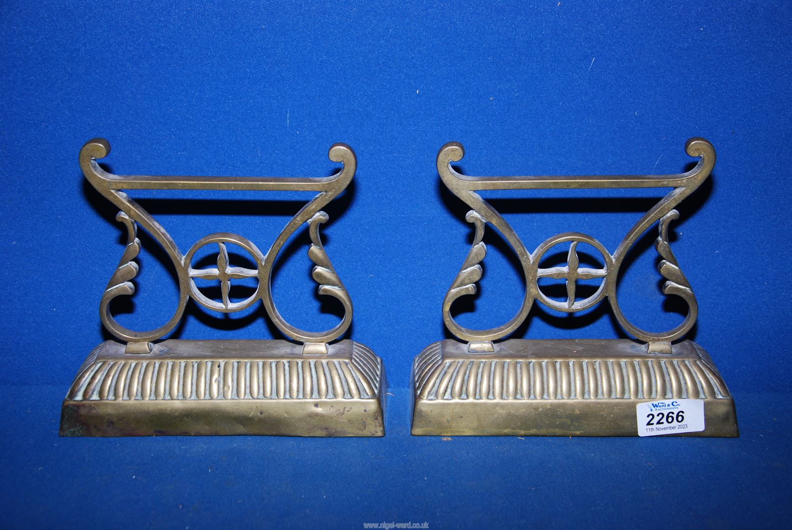 A pair of brass fire dogs, 7 1/2'' wide x 7 1/4'' high.