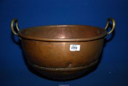 A large old copper mixing bowl having brass handles with the initials 'JB' and '380' engraved to