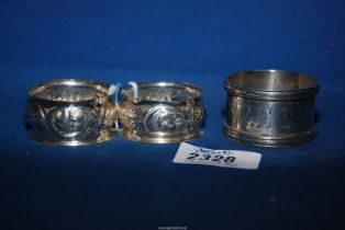 A pair of silver napkin rings, Chester (hallmarks rubbed) and a silver napkin ring, Birmingham 1880,