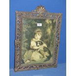 A Print of a young girl with dog in ornate metal frame.