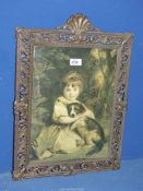 A Print of a young girl with dog in ornate metal frame.