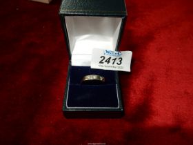 An unmarked modern style silver ring set with three diamonds.