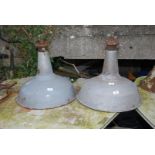 Two large enamelled industrial light shades.