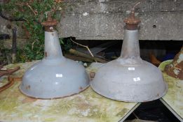 Two large enamelled industrial light shades.