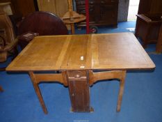 A light oak dropleaf table, 60'' open (30'' closed) x 36'' wide x 30'' high.