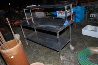 A stainless steel catering table, 65'' wide x 25 1/2'' deep x 50'' high with upper shelf.