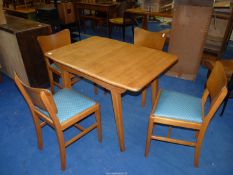 An extending kitchen table and four chairs, 29'' high x 60'' when open.