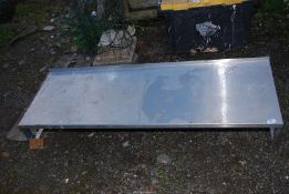 A low stainless steel table/shelf 58'' wide x 19'' deep x 8'' high.