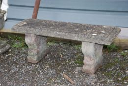 A concrete garden bench on plinth, 45'' wide x 14'' deep x 17'' high.