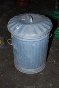 A galvanised dustbin with lid.