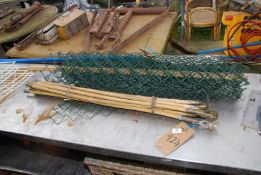 A roll of chain link fencing and bamboo drainage rods.