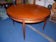 A circular extending dining table, 48'' diameter without leaf, 28 1/2'' high.