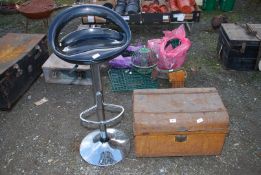 A small metal trunk and a rotating bar stool.