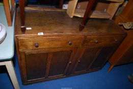 An oak sideboard with two drawers and lower cupboard with shelves,