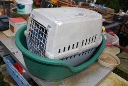 A large plastic dog bed and a cat house.