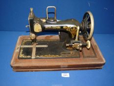 A Frister and Rossmann electric sewing machine in wooden case with key.