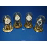 Four anniversary clocks including Kundo and Haller, two with glass domes, two with plastic domes.