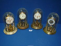 Four anniversary clocks including Kundo and Haller, two with glass domes, two with plastic domes.