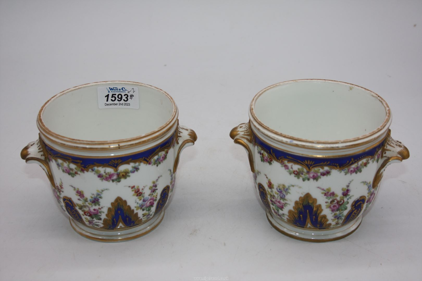 A pair of small Urns with blue, gilt and floral decoration, blue cross swords mark to base.
