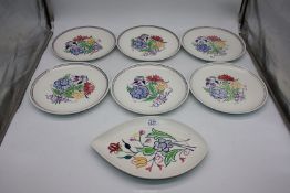 Seven Poole Pottery plates.