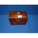 A Mahogany sarcophagus shaped tea caddy with two compartments.