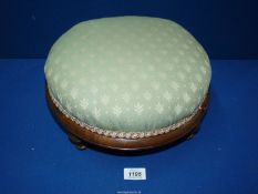 A Walnut framed low circular Footstool having a green upholstered top, 12 1/2'' diameter x 6'' high.