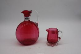 Two cranberry glass jugs.